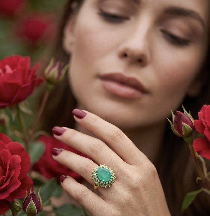 Elizabeth oval cut 22.8 carat Colombian Emerald 22K Gold over .925 Sterling Silver handcrafted Ring size 6 3/4 - Emerald ring worn on hand among red roses, close-up view.