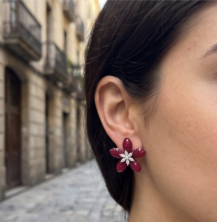 Giuseppina - mystery setting 7.8 carat authentic Ruby .925 Sterling Silver handcrafted Statement earrings - Ruby floral earrings worn on ear, street background.