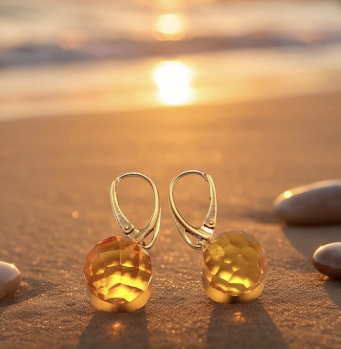 Faceted spheres authentic 11.2 carat Golden Baltic Amber 18K Gold over .925 Sterling Silver Earrings - Close-up of faceted Golden Baltic Amber earrings on sandy beach background.