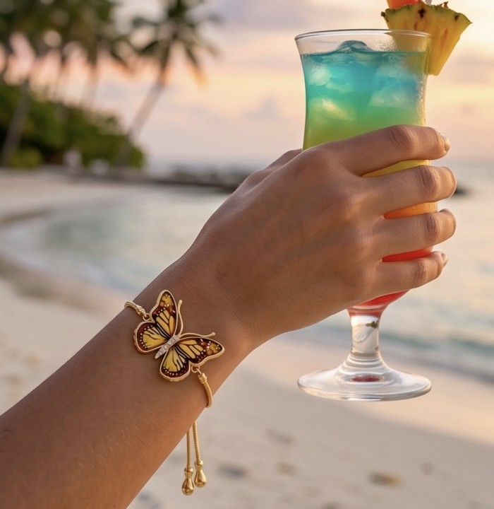 Golden Butterfly Genuine carved Baltic Amber 18K Gold over .925 Sterling Silver handamde Bracelet - Worn on hand, butterfly bracelet with drink and beach background.