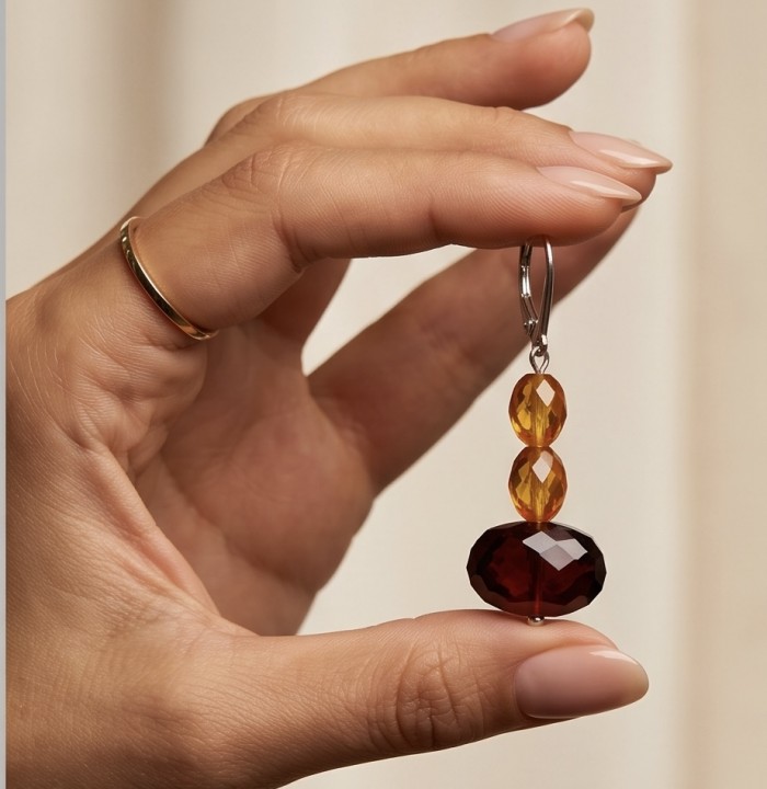 Luminous fossilized Beauty natural Baltic Amber .925 Sterling Silver entirely handcrafted earrings - Close-up of Baltic amber earring held by hand