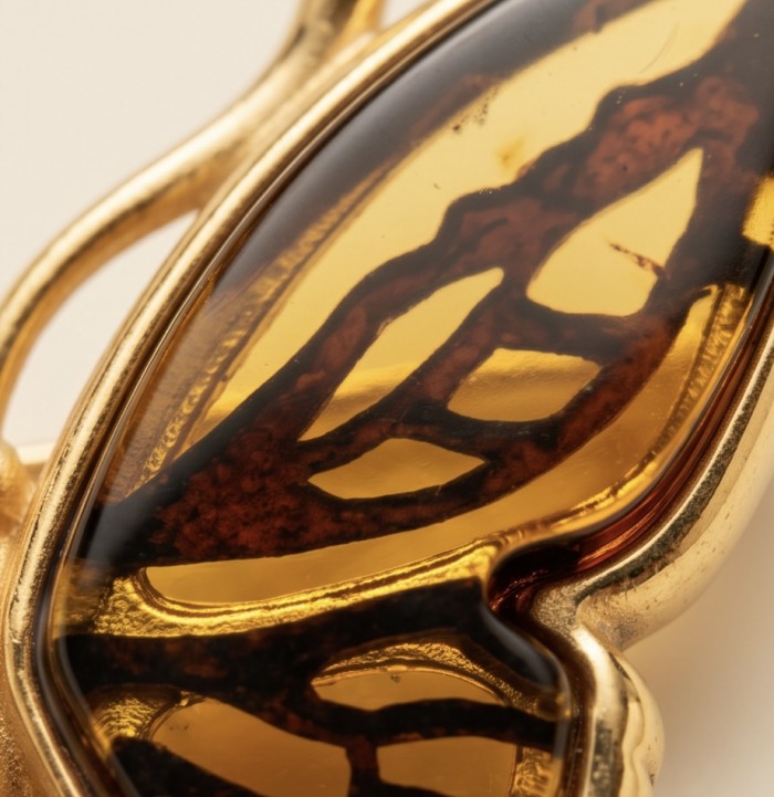 Golden Butterfly natural carved Baltic Amber .925 Sterling Silver dipped in 22K Real Gold handmade Pendant - Amber stone close-up with gold butterfly design in jewelry piece.
