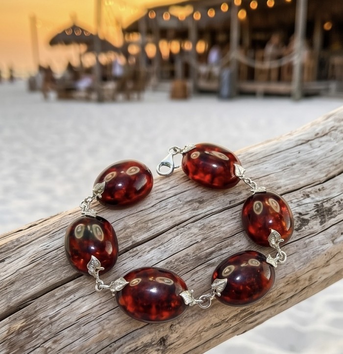 Excellent quality Cognac color Baltic Amber .925 Sterling Silver entirely handcrafted Bracelet - Cognac Baltic amber bracelet on driftwood, beach setting in background.