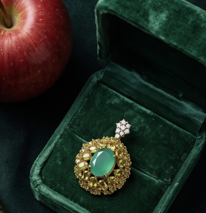 Green Royalty - 8.8 carat Colombian Emerald 6.4 carat Peridot .925 Sterling Silver dipped in 22K Gold handmade Statement pendant - Emerald pendant in green velvet box next to red apple, top view.