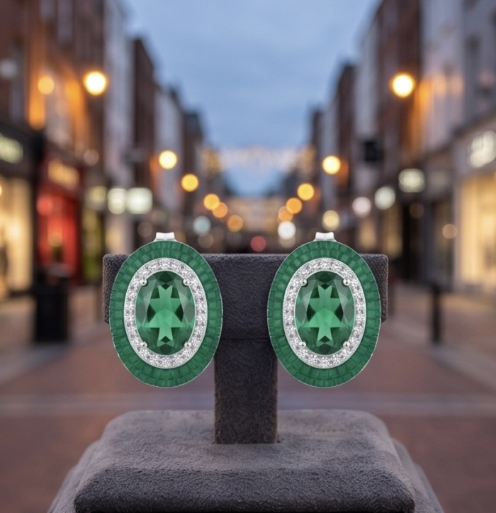 Julietta 12.5 carat Colombian Emerald .925 Sterling Silver handmade Statement earrings - Emerald earrings on display with blurred city backdrop