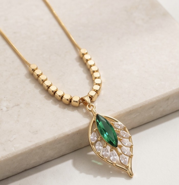 Luxurious 8.9 carat Chrome Diopside 18k Gold over .925 Sterling Silver handmade Necklace - Gold necklace with green and white stones, close-up view on surface.