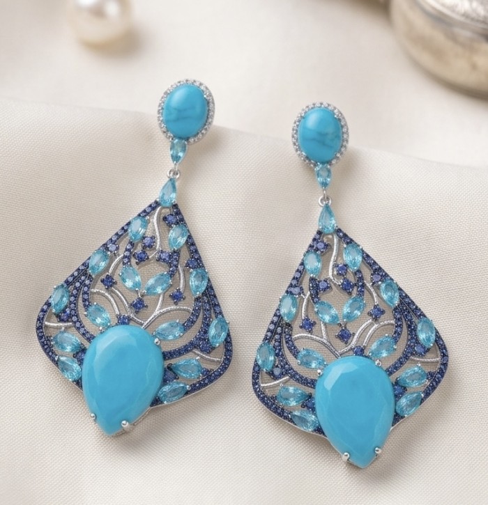 Pacifica - 14.4 carat Sleeping Beauty Turquoise 4.8 carat Swiss Blue Topaz .925 Sterling Silver handmade Statement Earrings - Elegant turquoise earrings on fabric, front view with stone detail.