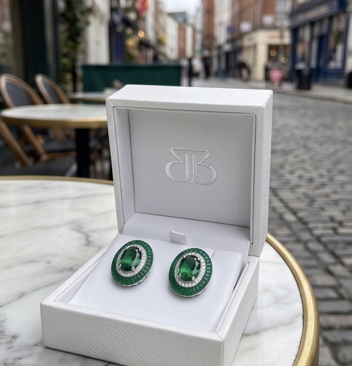 Julietta 12.5 carat Colombian Emerald .925 Sterling Silver handmade Statement earrings - Close-up of emerald earrings in box on outdoor table.