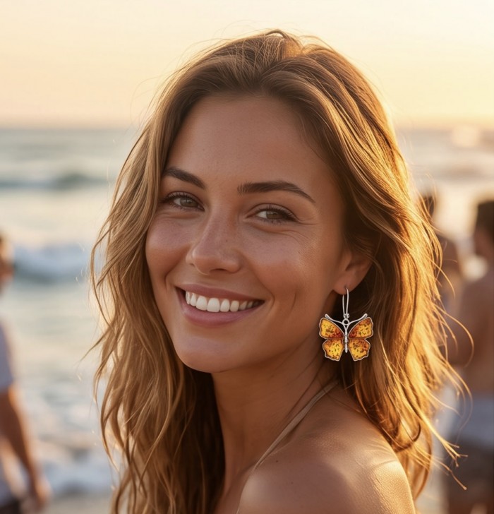 Golden Butterflies carved Baltic Polish Amber .925 Sterling Silver earrings - Woman wearing golden butterfly amber earrings at the beach