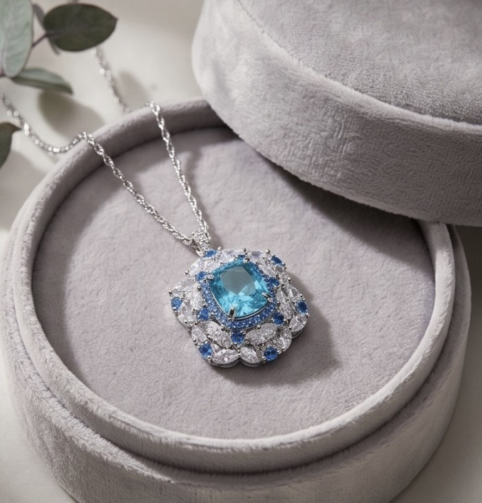 Mademoiselle - 21.5 carat natural Swiss Blue Topaz .925 Sterling Silver dipped in Rhodium handcrafted Necklace - Necklace with blue topaz in open box, top view.