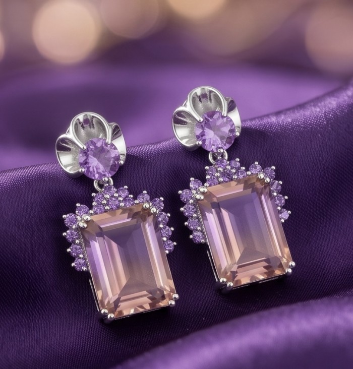 Charlotte Authentic 14.4 carat Green Ametrine rhodium over .925 Sterling Silver handcrafted Statement Earrings - Close-up of ametrine and purple gemstone earrings on purple fabric