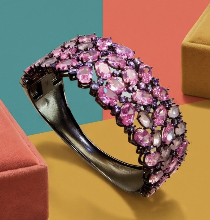 Luxurious 45.4 carat Pink Sapphire 1.8 carat Tanzanite 8.2 carat Rose Quartz black rhodium over .925 Sterling Silver handcrafted Bracelet - Side view of pink sapphire and tanzanite bracelet on colorful backdrop.