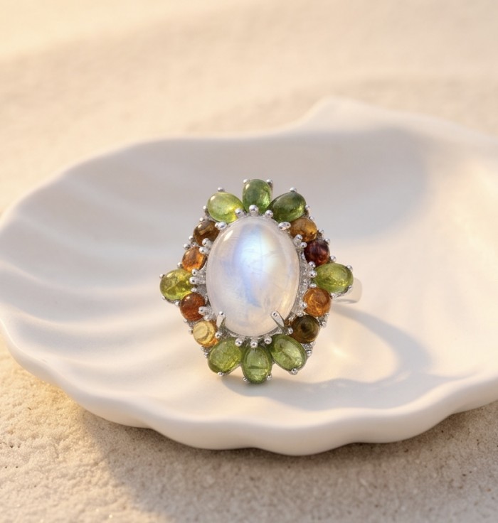 Angelina - Top quality 22.2 carat Brazilian Rose Quartz .925 Sterling Silver dipped in rhodium Handcrafted Ring size 6 - Ring with moonstone and multicolor gems on a dish, top view.