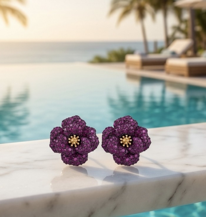 Exotic Flowers - 18.8 carat Mozambique Ruby .925 Sterling Silver dipped in rhodium 22K Gold handmade Statement Earrings - Close-up of flower-shaped ruby earrings by a pool with ocean view.