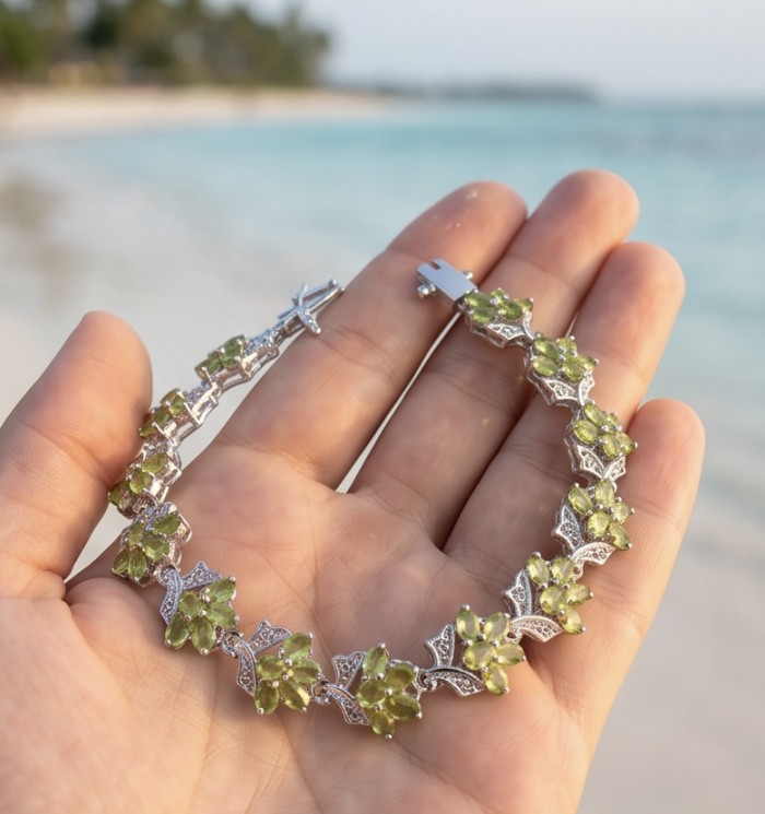 Vittoria Natural 29.8 carat Brazilian Peridot Rhodium over .925 Sterling Silver handmade Statement Bracelet - Hand holding Vittoria peridot bracelet on beach background.