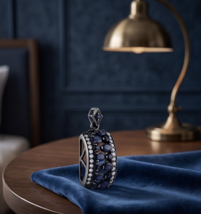 Vintage Beauty 9.7 carat Mozambique Sapphire Black Rhodium over .925 Sterling Silver handcrafted pendant - Side view of Vintage Beauty Sapphire Black Rhodium pendant on table.