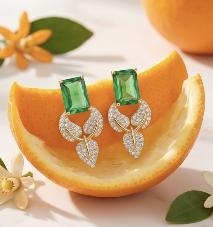Luxurious 10.9 carat authentic Himalayan Peridot .925 Sterling Silver dipped in 14K Gold Handcrafted Statement Earrings - Earrings with green stones, detailed view with orange backdrop.