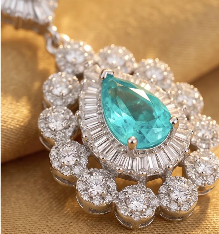 Estelle - Authentic 4.5 carat COLOMBIAN EMERALD .925 Sterling Silver handcrafted Statement earrings - Close-up of Estelle emerald and diamond pendant on gold fabric background.