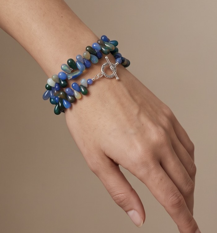 Sublime Brilliance Authentic Black Opal .925 Sterling Silver handcrafted bracelet - Bracelet worn on hand, featuring colorful opal beads and heart clasp detail.