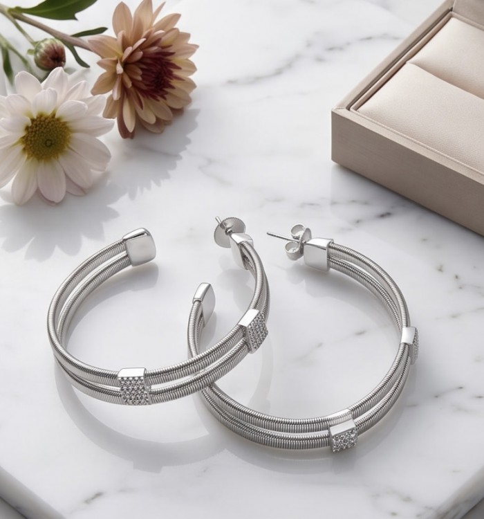 Extravaganza 4.5 carat White Topaz rhodium over .925 Sterling Silver handmade Hoop Earrings - Elegant hoop earrings with floral decor on marble background, top view.