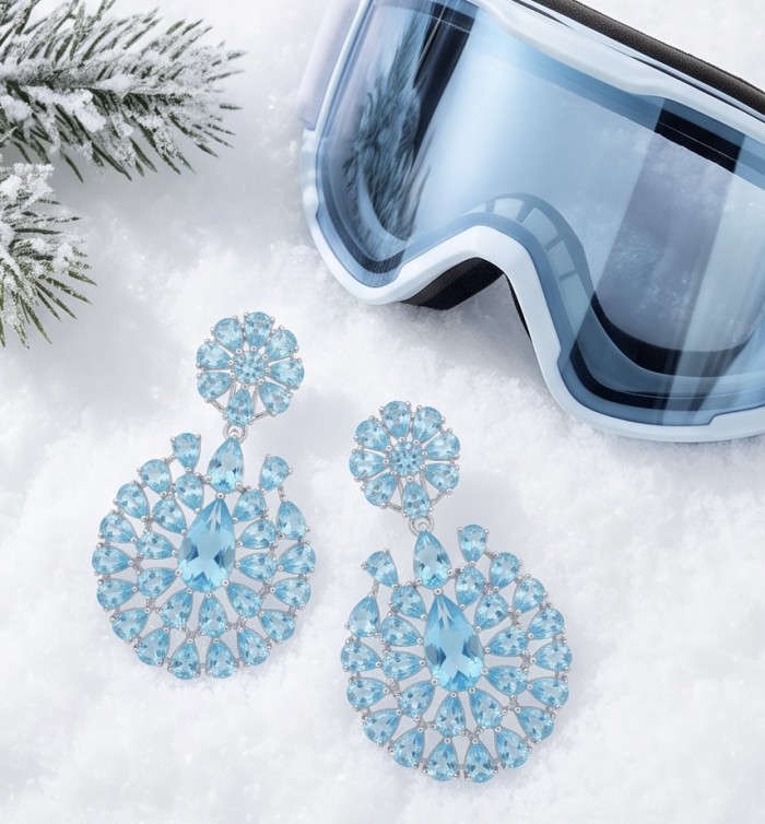 Tranquillity - 27.7 carat carved Swiss Blue Topaz .925 Sterling Silver dipped in Rhodium Handcrafted Statement earrings - Blue topaz earrings on snow with ski goggles, top view.