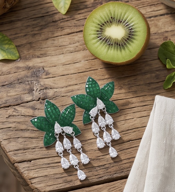 Born to Glam authentic 10.7 carat mystery setting Colombian Emerald .925 Sterling Silver handcrafted Statement earrings - Top view of emerald and diamond earrings on wooden surface with kiwi.