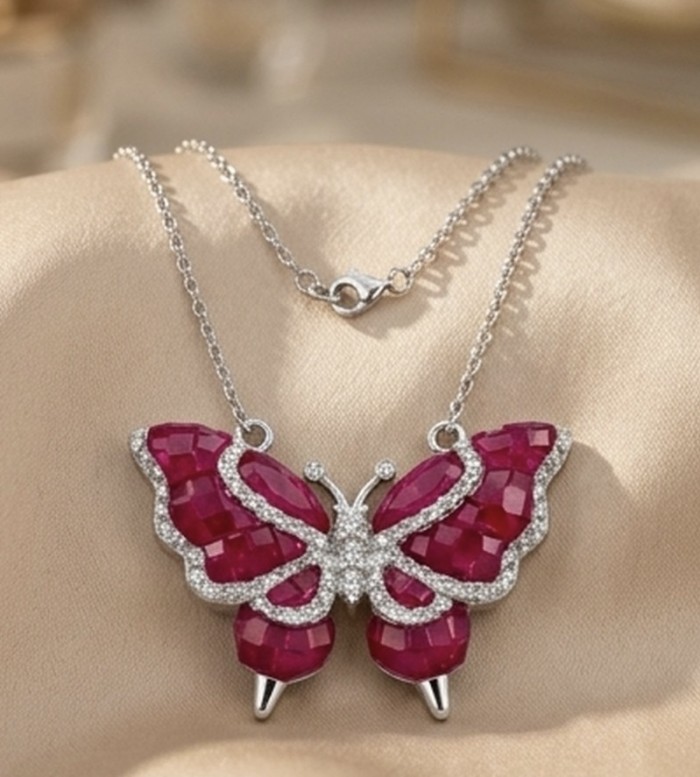 Red Butterfly Luxurious MYSTERY SETTING natural 12.5 carat Ruby .925 Sterling Silver handmade Statement necklace - Red butterfly necklace, front view, on beige fabric background.
