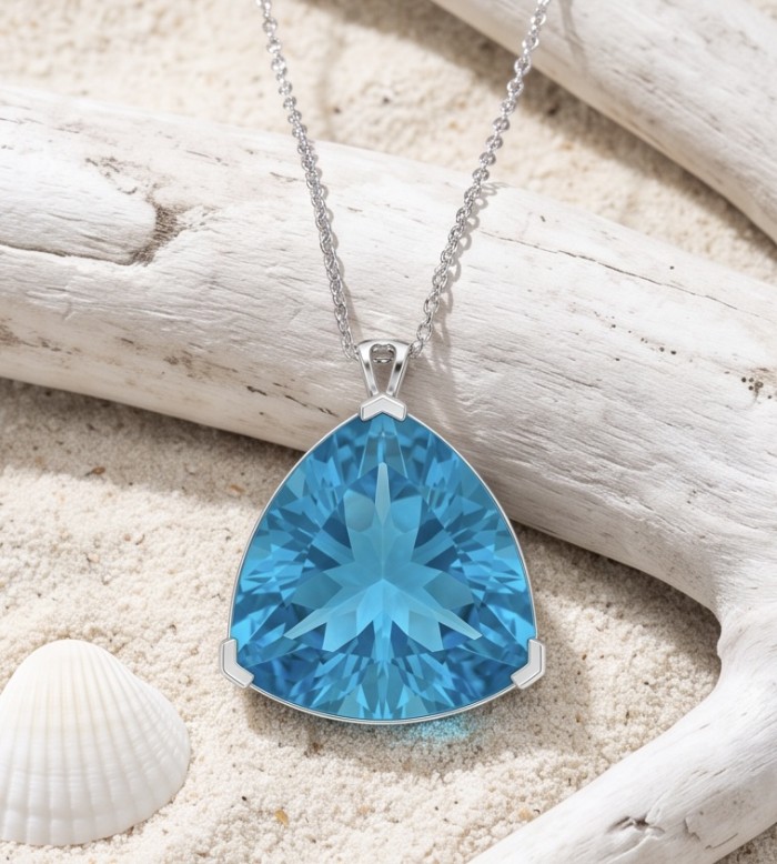 Trillion cut 28.5 carat Vintage style Swiss Blue Topaz .925 Sterling Silver DIPPED IN RHODIUM handmade Pendant - Close-up of trillion-cut Swiss Blue Topaz pendant on sand and driftwood.