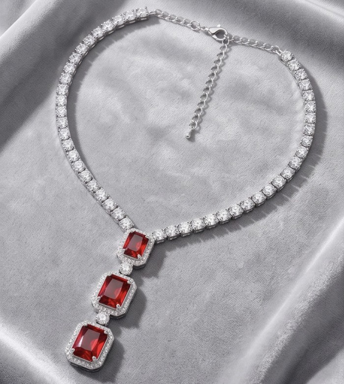 Serafina - Magnificent Jewel 9.8 carat Ruby .925 Sterling Silver handcrafted incredible Statement Necklace - Necklace with red gems and silver clasp detail on grey fabric backdrop.