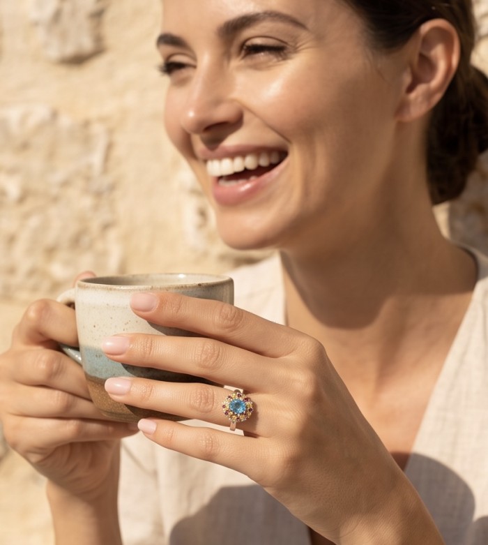 Atlantica 2.8 carat Swiss Blue Topaz .925 Sterling Silver dipped in rhodium handcrafted ring size 7 - Woman wearing Atlantica Swiss Blue Topaz ring, holding a mug, smiling