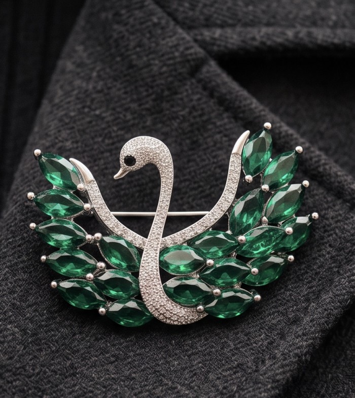 Graceful Swan Genuine 19.5 carat Colombian Emerald .925 Sterling Silver handmade Pendant - Brooch - Swan brooch with emerald stones, front view on dark fabric.