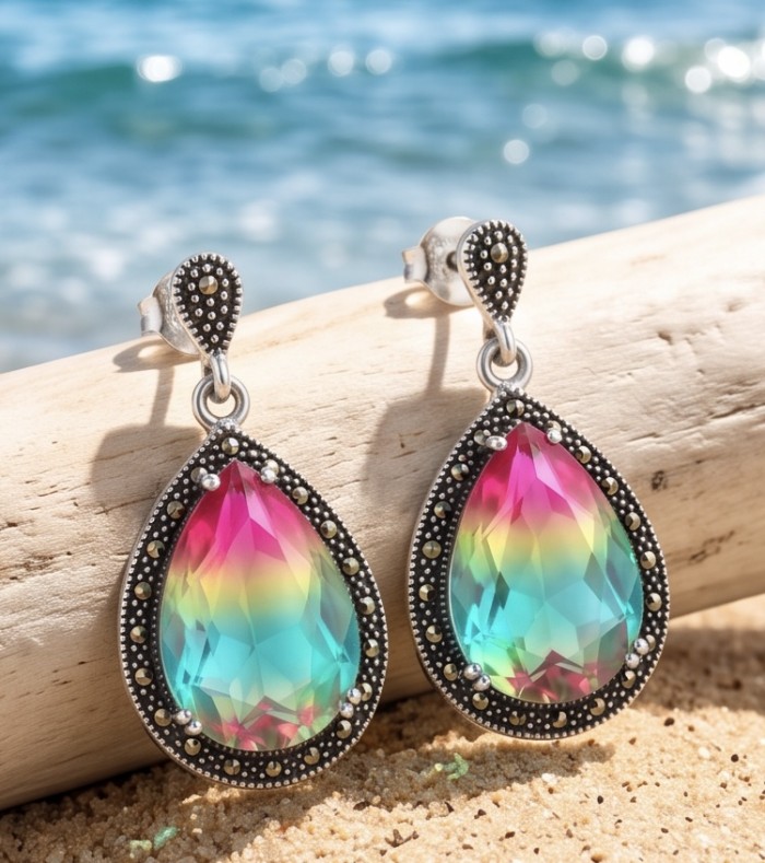 Rainbow authentic 25.5 carat Tourmaline rhodium over .925 Sterling Silver handcrafted Statement Earrings - Close-up of teardrop rainbow tourmaline earrings on sandy background.