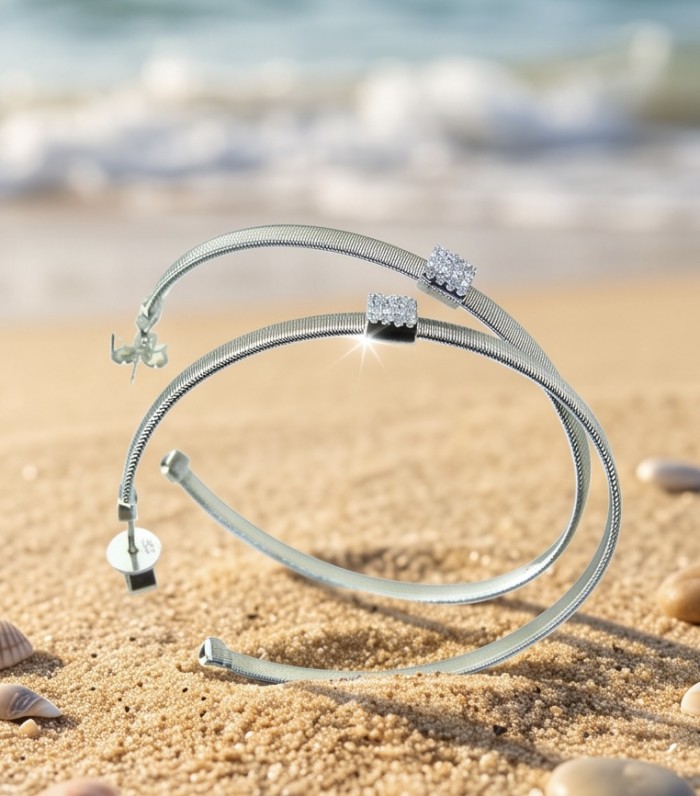 Huge 2 1/8 inches long White Topaz rhodium over .925 Sterling Silver handmade Hoop Earrings - Side view of large white topaz bracelets on sandy beach background.