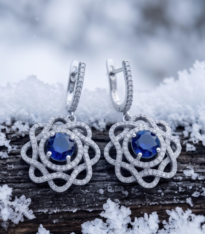 Authentic pear cut 4.1 carat Sapphire .925 Sterling Silver handcrafted earrings - Elegant sapphire earrings on snowy wood, front view.