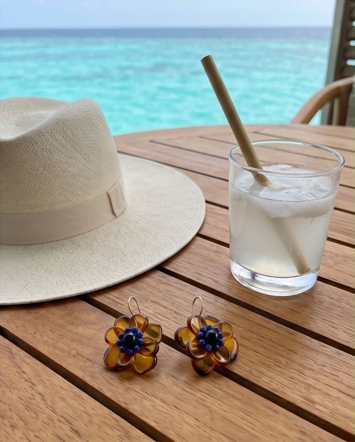 Summer Flowers Wonderful natural Baltic Amber 14K Gold over .925 Sterling Silver entirely handcrafted earrings - Amber flower earrings on wooden table with beach hat and drink.